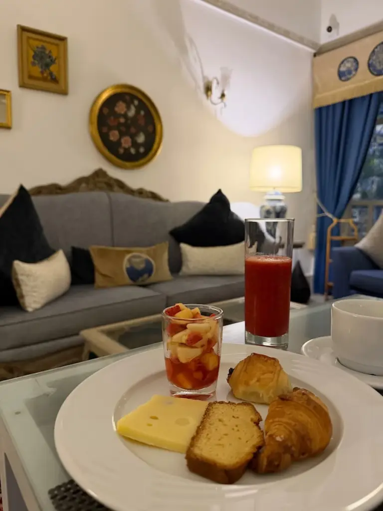 Breakfast at Dar Said in Sidi Bou Said. There is a glass of strawberry juice, pastries, cheese, bread, cake and a fresh fruit salad, Tunisia