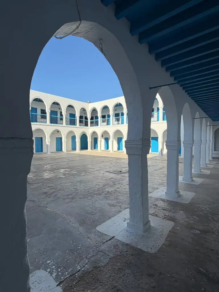 The courtyard archways of El Ghriba Synagogue, Djerba. The archways are painted white with blue doors