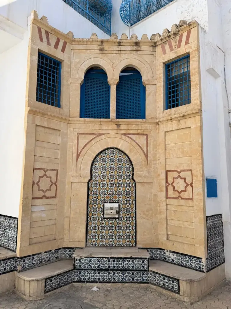 Intricate doorway in Kairouan Medina with blue top windows and a blue  adn white tiled entranceway
